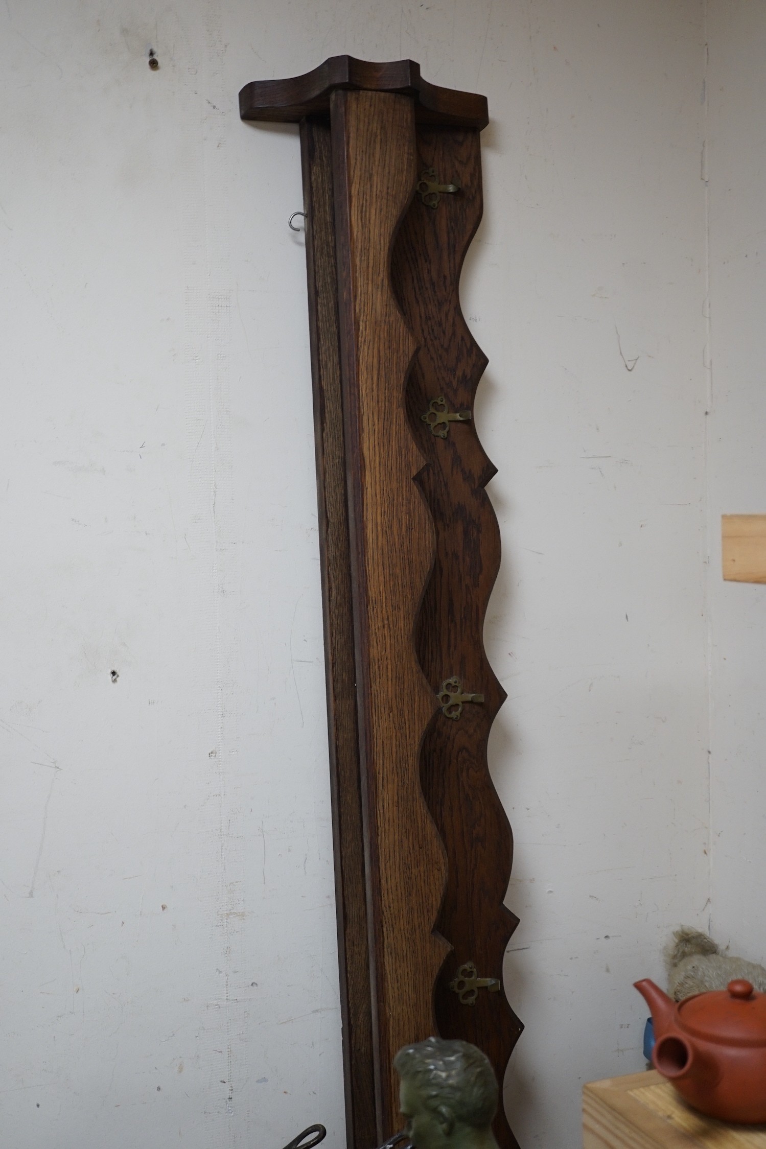 A matching set of five graduating copper pans and an oak pan rack